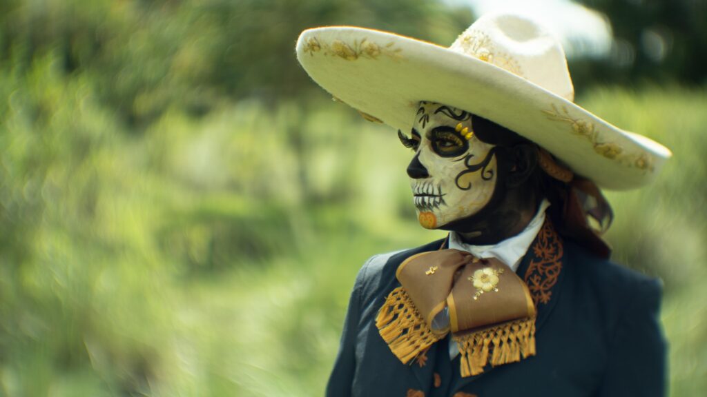 A woman in a mexican costume with a skull mask
