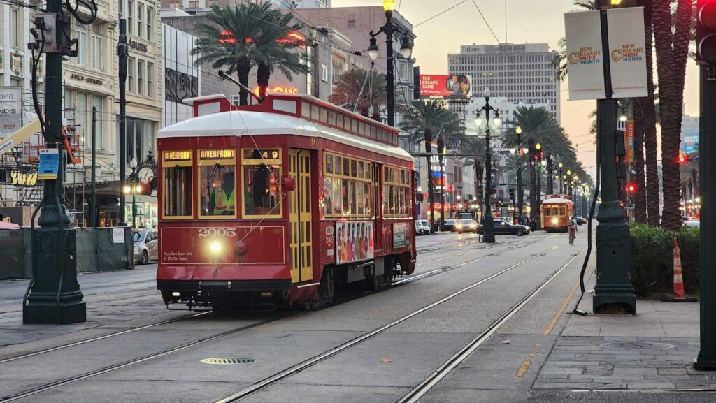 A row of vibrant red streetcars gliding gracefully along Canal Street